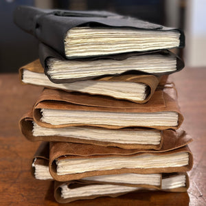 A stack of rustic wrap leather journals in colour brown, chestnut and black