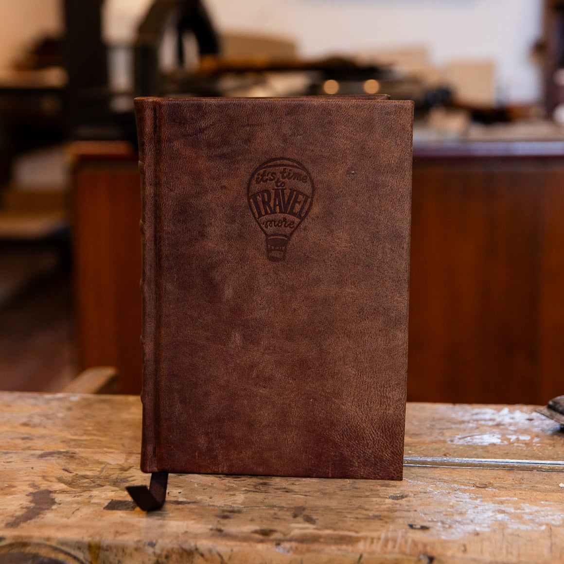 Handcrafted small leather journal featuring embossed logo of hot air ballonn saying 'Time to Travel More'