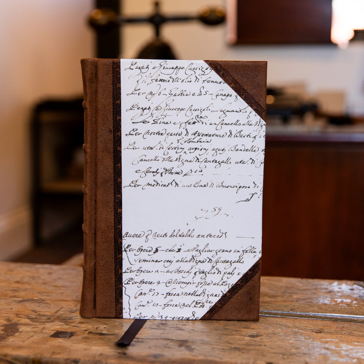 Handbound half leather journal from SB Libris with aged goatskin spine and vintage script paper cover.