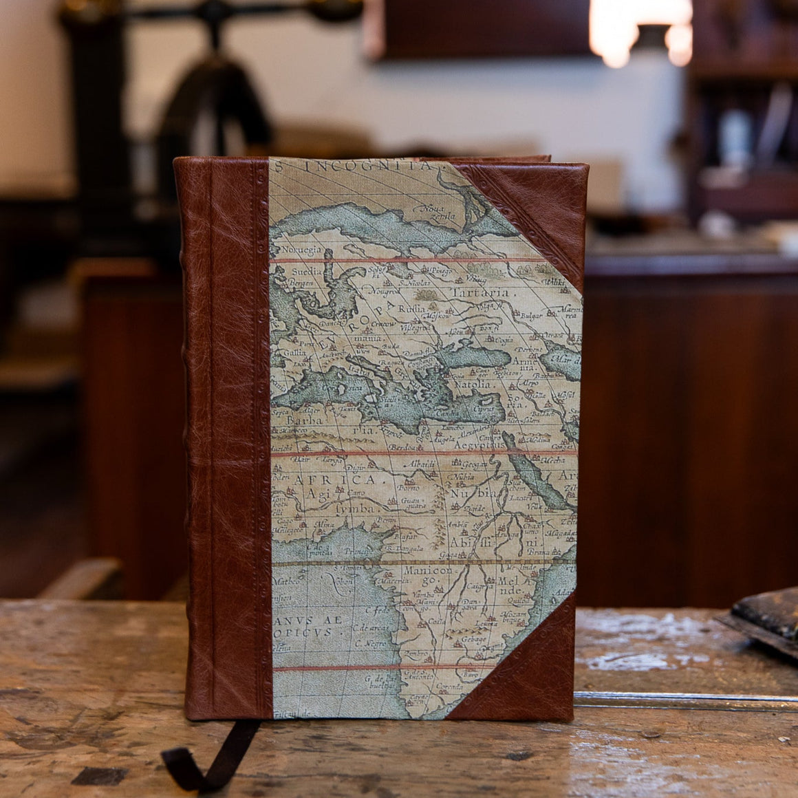 Small handbound half leather journal by SB Libris with antique map printed paper and aged brown leather detailing.