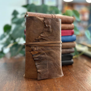 A leather wrap style journal in aged brown goatskin