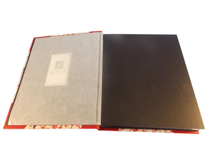 Open view of red leather album showing interleaving tissue