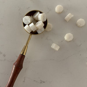 Wax sealing granules in melting spoon